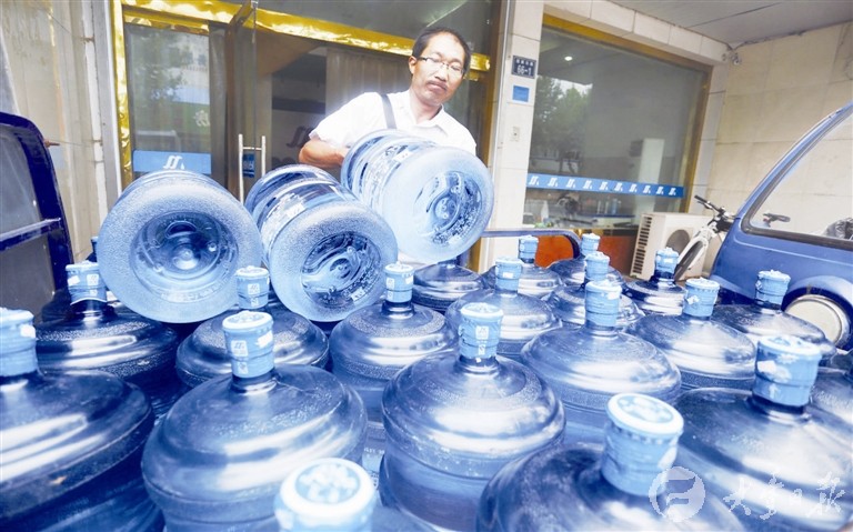 李亚国把要送的水搬上三轮车.