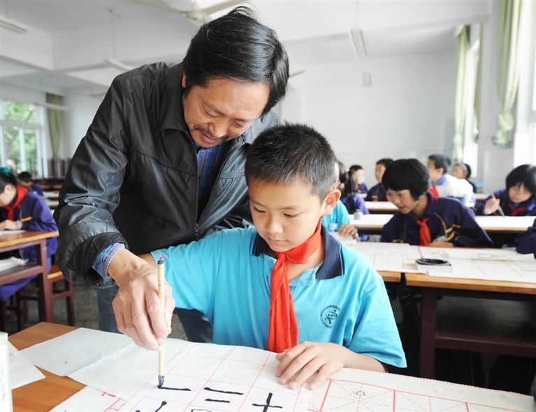 图为书法老师在辅导学生写字.          记者  金凯华  摄