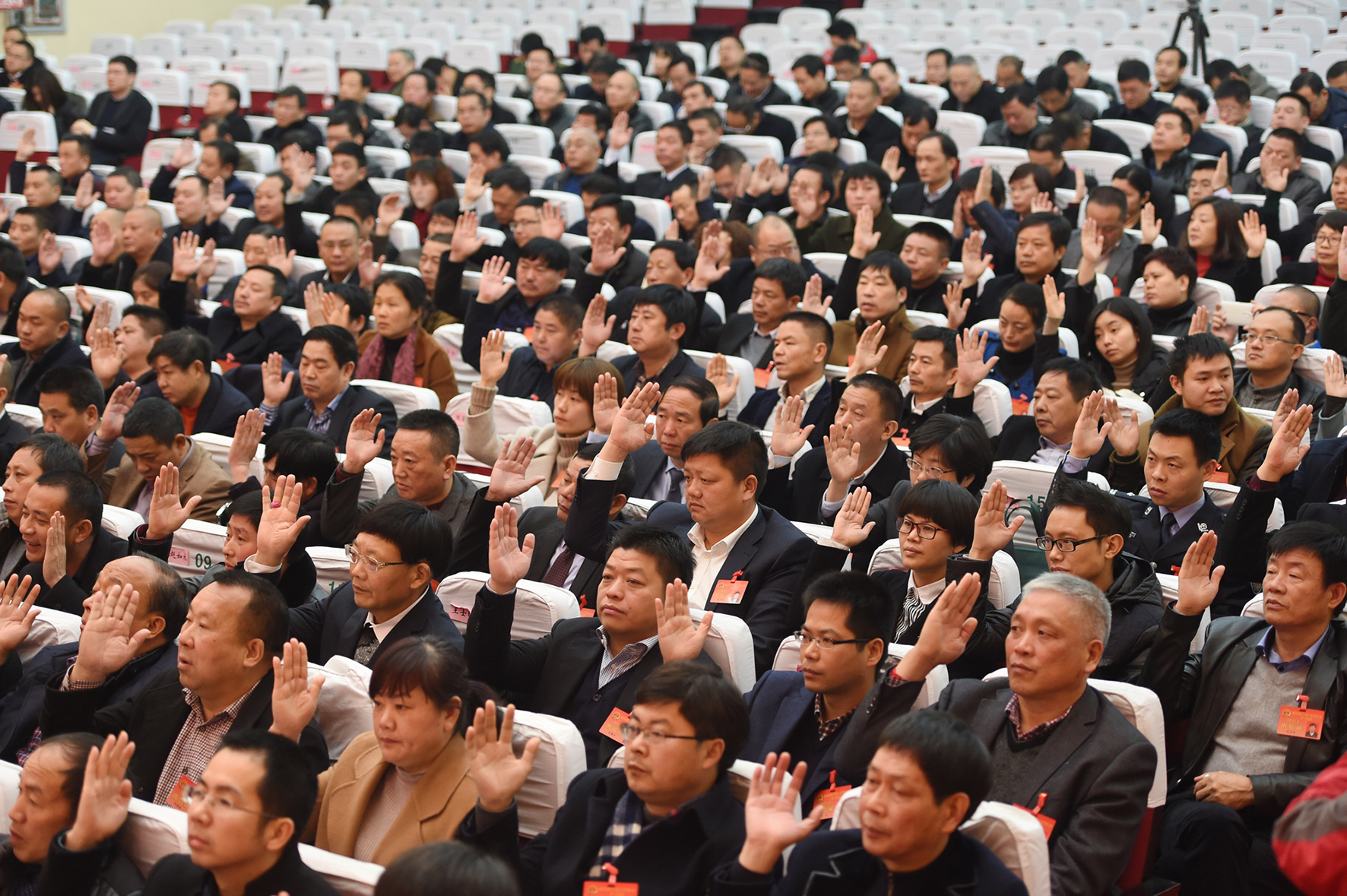 市人大十六届一次会议举行闭幕会,代表举手表决