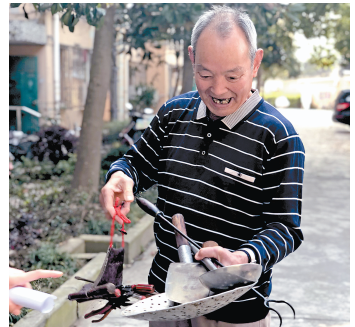 居民杨宏昌将自己当乡宴厨师时的爪篱,炒勺等老物件送到居委.