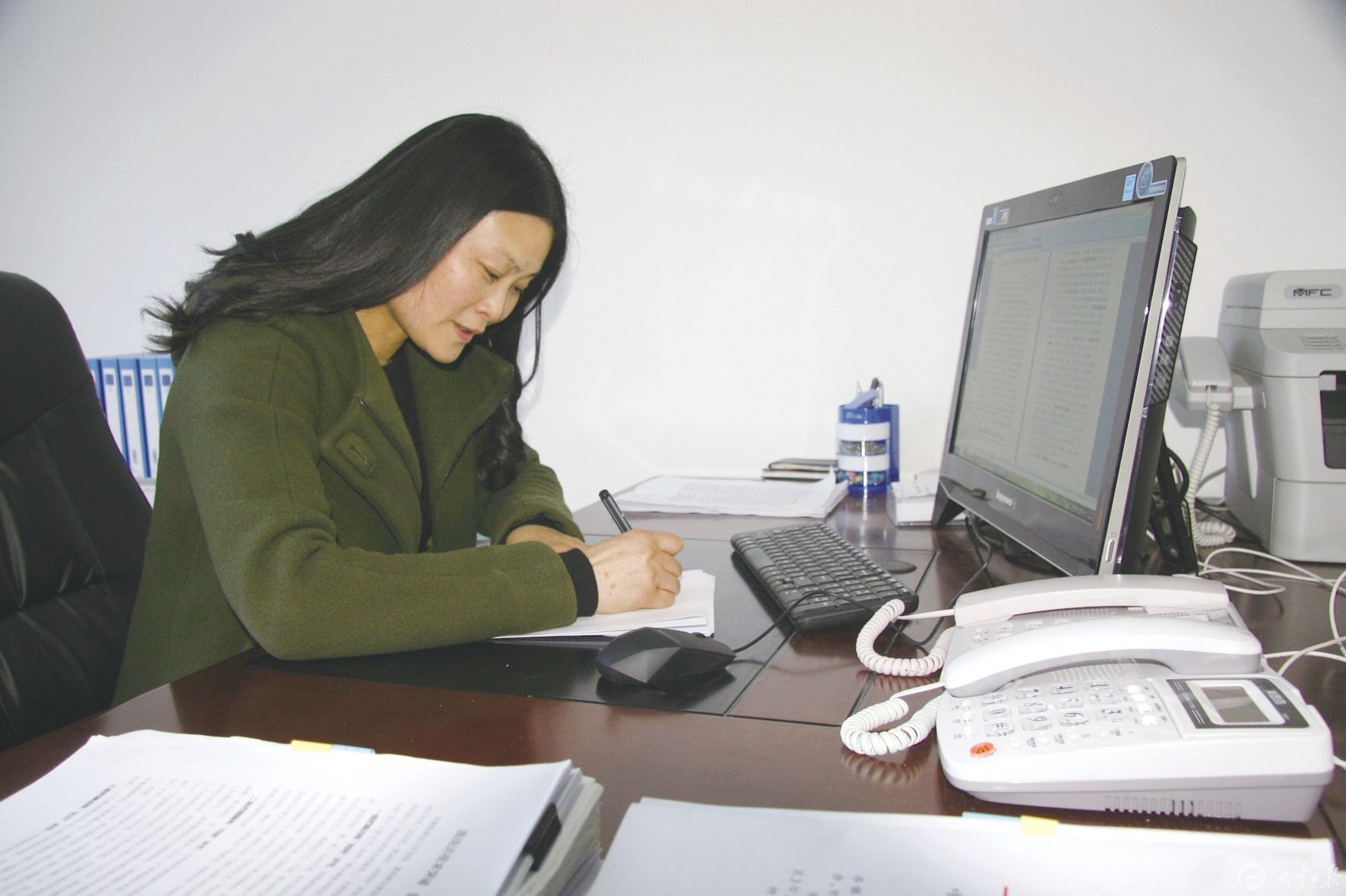 陈雪在办公室整理工作资料.