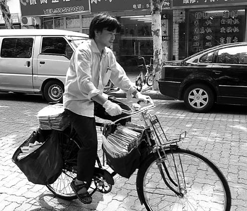 图为在烈日下奔走的邮递员