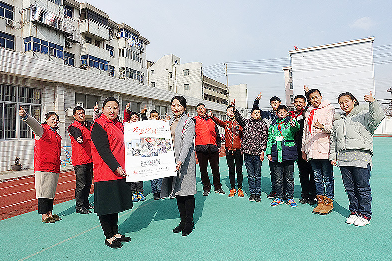 高雁(前排左一)向区特殊教育学校少先队大队部赠送"志愿扬州"宣传画